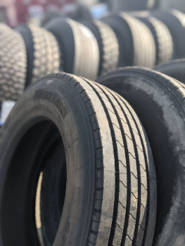 Closeup photo of commercial truck tires for sale in Glenwood and Council Bluffs, IA. The truck tires are lined up and you can see more in the background